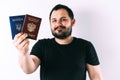 A man with a beard holding a passport of Russia and Ukraine translation: - Ukraine. Passport, Russian Federation Royalty Free Stock Photo