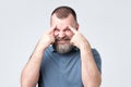 Man with beard holds fingers on temples, trying to remember something. Royalty Free Stock Photo