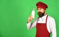 Man with beard holds glass bottle on green background Royalty Free Stock Photo