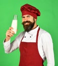 Man with beard holds glass bottle on green background. Royalty Free Stock Photo