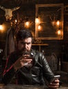 Man with beard holds glass brandy. Macho drinking. Degustation, tasting. Handsome stylish bearded man is drinking