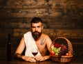 Man with beard holds glass of wine on wooden background Royalty Free Stock Photo