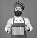 Man with beard holds kitchenware on blue background. Professional cookery concept. Cook with happy face in burgundy