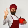 Man with beard holds red pot on white background