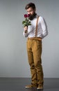 A man with a beard holds rose