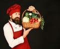 Man with beard holds veggies on black background. Royalty Free Stock Photo