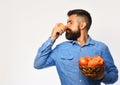 Man with beard holds wicker bowl with apple fruits