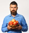 Man with beard holds wicker bowl with fruit