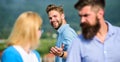 Man with beard jealous aggressive because girlfriend interested in handsome passerby. Husband strictly watching his wife Royalty Free Stock Photo