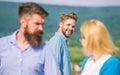 Man with beard jealous aggressive because girlfriend interested in handsome passerby. Jealous concept. Passerby smiling Royalty Free Stock Photo