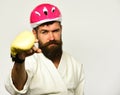 Man with beard in kimono and pink helmet on white Royalty Free Stock Photo