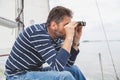 Man with beard looks through binoculars on sailing yacht Royalty Free Stock Photo