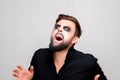 man with a beard and makeup in the style of the undead on Halloween opened his mouth and shows his teeth