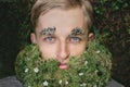 Man with beard from moss, grass, flowers. Fairytale creature leprechaun