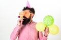 Man with beard and mustache on calm face holds air balloons, white background. Hipster in giant sunglasses celebrating