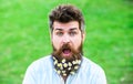 Man with beard and mustache enjoy spring, green meadow background. Springtime concept. Hipster on shocked surprised face Royalty Free Stock Photo