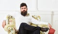 Man with beard and mustache sits on armchair, holds book, white wall background. Connoisseur on thoughtful face finished Royalty Free Stock Photo