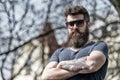Man with beard and mustache on strict face, nature background, defocused. Bearded man wears stylish sunglasses. Hipster Royalty Free Stock Photo