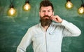 Man with beard and mustache on thoughtful face stand in front of chalkboard. Guy thinking with thoughtful expression Royalty Free Stock Photo