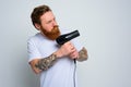 Serious man with beard play with hair dryeras a handgun