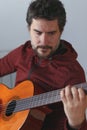 man with beard playing Spanish guitar looking at the strings Royalty Free Stock Photo