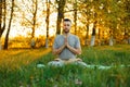 Man with a beard practicing yoga on nature at sunset. Royalty Free Stock Photo