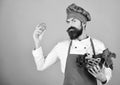 Man with beard on red background. Chef holds lettuce, garlic