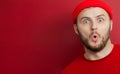 Man with a beard in a red hat opened his mouth in surprise. product advertising Royalty Free Stock Photo