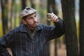 Man with a beard in scottish cap holds in hand the round flask