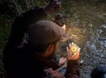 a man with a beard on the seashore holds a compass and a kerosene lamp