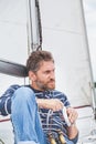 Man with beard sits on deck of sailing yacht Royalty Free Stock Photo