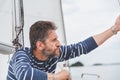 Man with beard sits on deck of sailing yacht Royalty Free Stock Photo