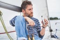 Man with beard sits on deck of sailing yacht Royalty Free Stock Photo