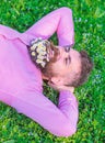 Man with beard on smiling face enjoy nature. Hipster with bouquet of daisies in beard relaxing. Unite with nature Royalty Free Stock Photo