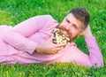 Man with beard on smiling face enjoy nature. Masculinity concept. Bearded man with daisy flowers lay on meadow, lean on Royalty Free Stock Photo