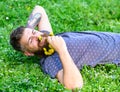 Man with beard on smiling face enjoy spring. Bearded man with dandelion flowers in beard lay on meadow, grass background Royalty Free Stock Photo