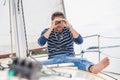 Man sits on sailing yacht and looks through binoculars Royalty Free Stock Photo