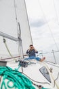 Man sits on sailing yacht and looks through binoculars Royalty Free Stock Photo
