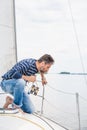Man sits on bow of sailing yacht and looks overboard Royalty Free Stock Photo