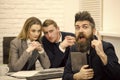 Man with beard on surprised face holds laptop, bosses, coworkers, colleagues on background. Man got job, successful Royalty Free Stock Photo