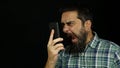 Man with beard talking on the phone screaming and shouting angry and furious Royalty Free Stock Photo