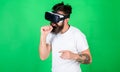Man with beard in VR glasses, green background. Guy with VR glasses singing with imaginary microphone. Hipster on busy