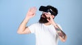 Man with beard in VR glasses, light blue background. VR gadget concept. Guy with head mounted display interact in Royalty Free Stock Photo