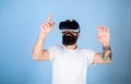 Man with beard in VR glasses, light blue background. Hipster on busy face exploring virtual reality with gadget. Guy Royalty Free Stock Photo
