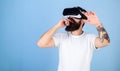 Man with beard in VR glasses, light blue background. Hipster on busy face exploring virtual reality with gadget Royalty Free Stock Photo