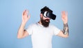 Man with beard in VR glasses, light blue background. Hipster on busy face exploring virtual reality with modern gadget Royalty Free Stock Photo