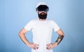 Man with beard in VR glasses serious and confident, light blue background. Architect or engineer with virtual reality