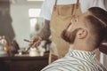 Man with a beard waits for a shave with a razor in a barbershop