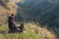 A man with a beard walking his dog in the nature, standing with a backlight at the rising sun, casting a warm glow and