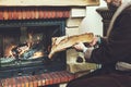 Man with beard wearing bathrobe puts log in burning fireplace Royalty Free Stock Photo
